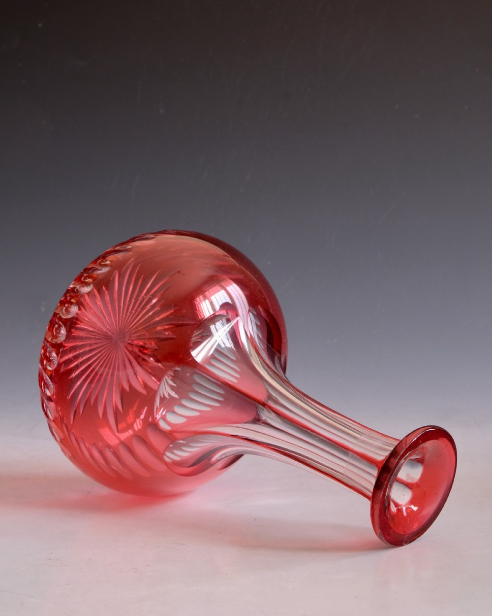 A mid-Victorian ruby overlay cut glass decanter with a matching faceted stopper and slice-cut neck. View VIII