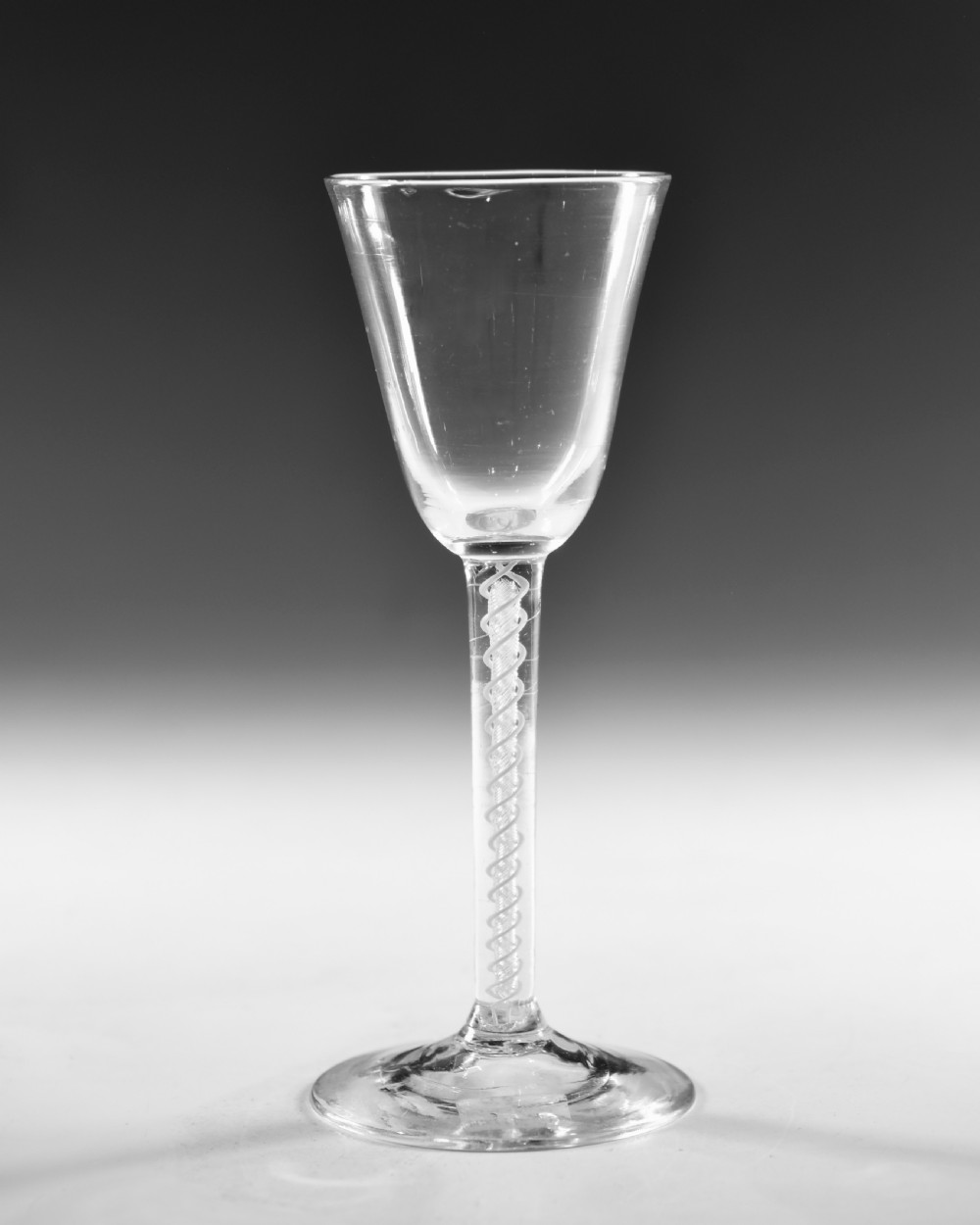 A clear Georgian lead crystal wine glass featuring a bell-shaped bowl, a mixed twist stem, and a circular conical foot. View II