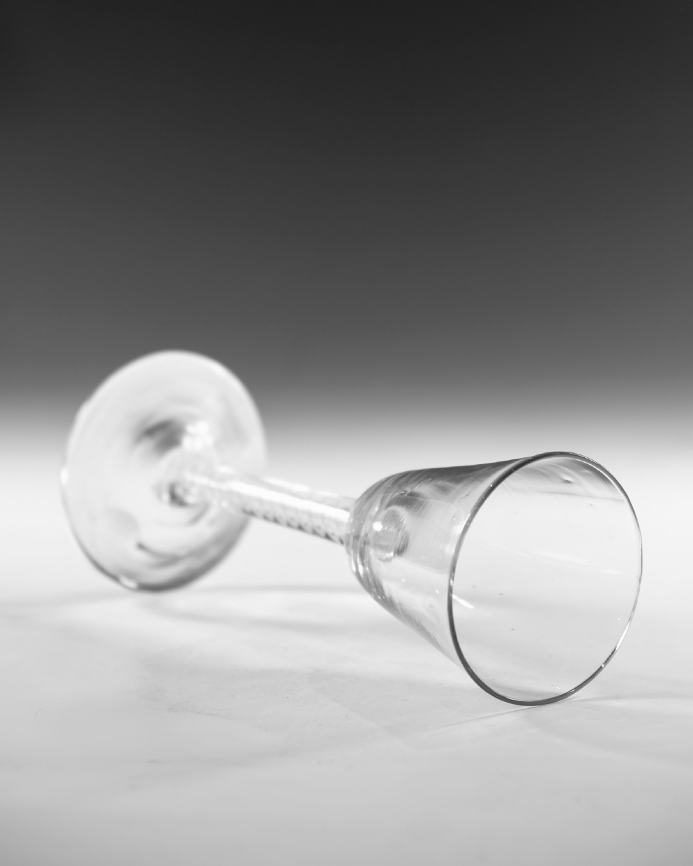 A clear Georgian lead crystal wine glass featuring a bell-shaped bowl, a mixed twist stem, and a circular conical foot. View V