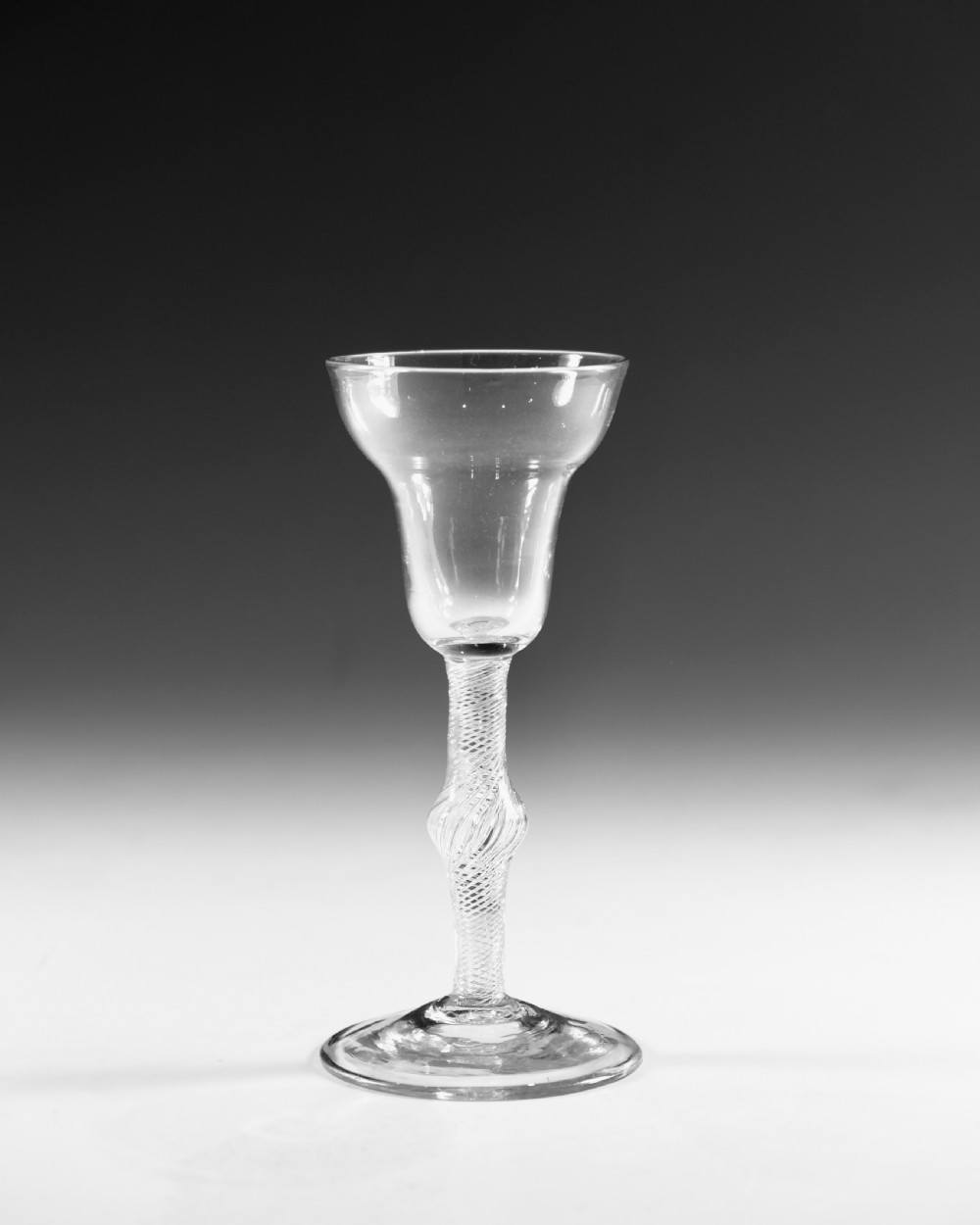 An 18th-century English clear lead glass wine glass featuring a flared bowl, a knopped stem with a multi-spiral air twist pattern, and a wide circular foot. View II