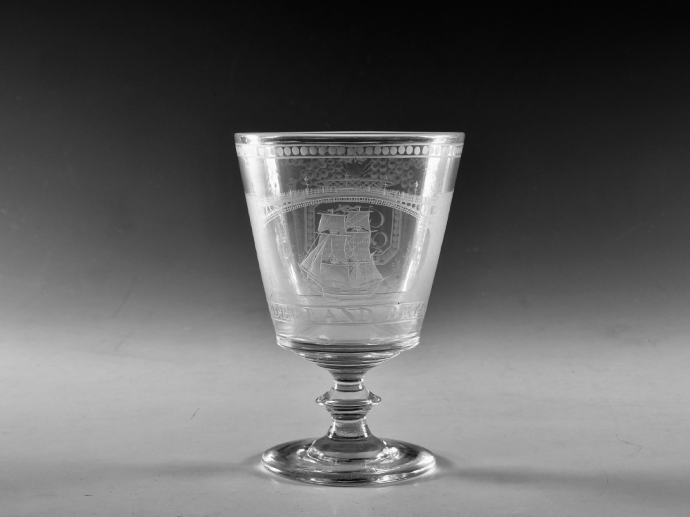 An antique clear glass rummer featuring detailed wheel engraving of a sailing ship beneath the Wearmouth Sunderland Bridge, supported by a knopped stem and circular foot.
