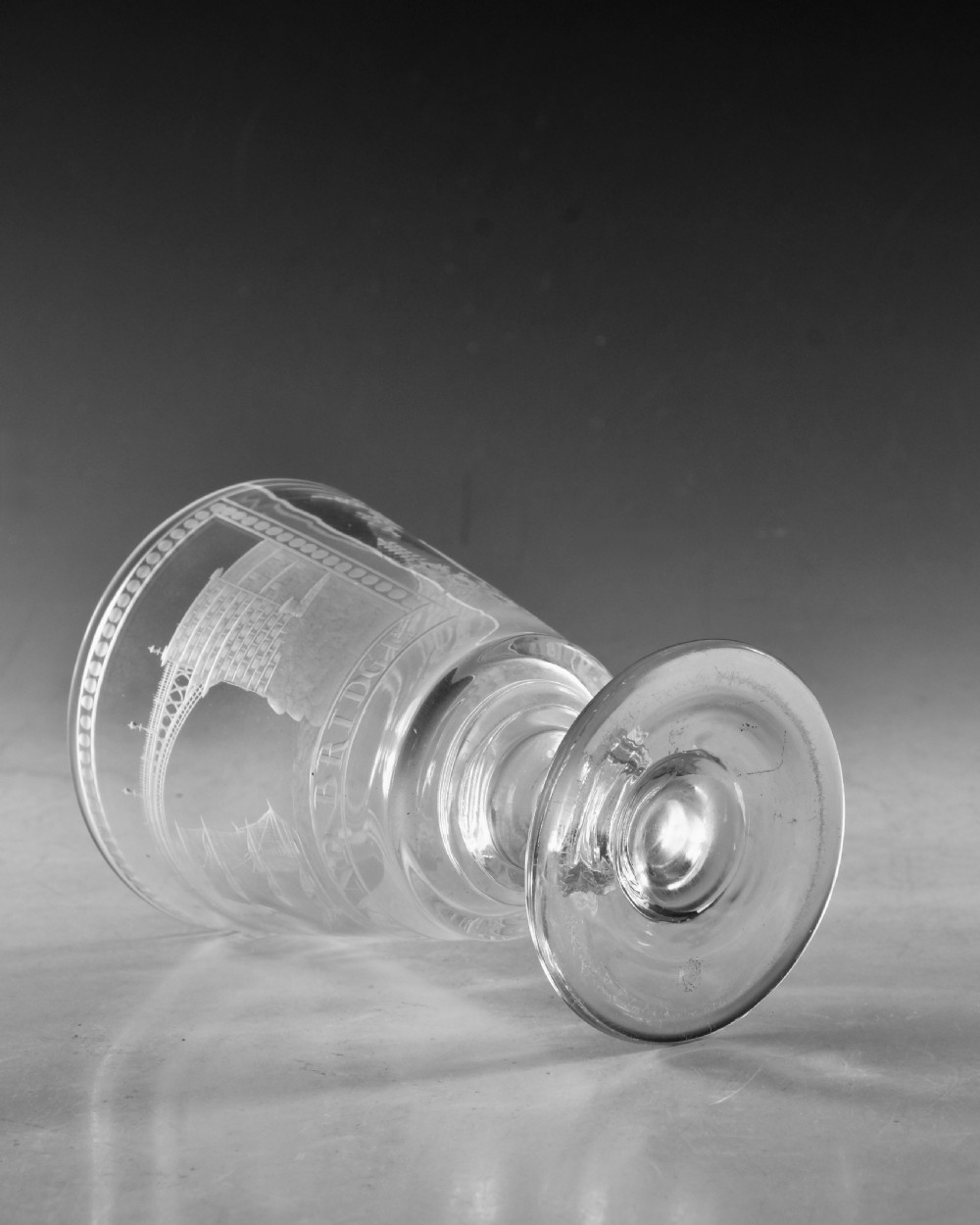 An antique clear glass rummer featuring detailed wheel engraving of a sailing ship beneath the Wearmouth Sunderland Bridge, supported by a knopped stem and circular foot. View VI