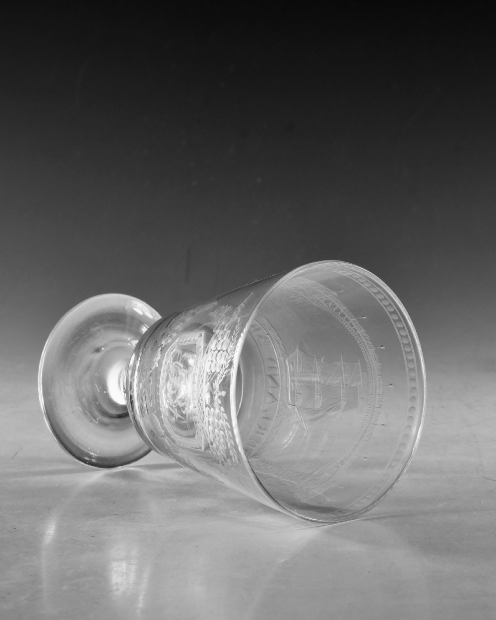 An antique clear glass rummer featuring detailed wheel engraving of a sailing ship beneath the Wearmouth Sunderland Bridge, supported by a knopped stem and circular foot. View VII