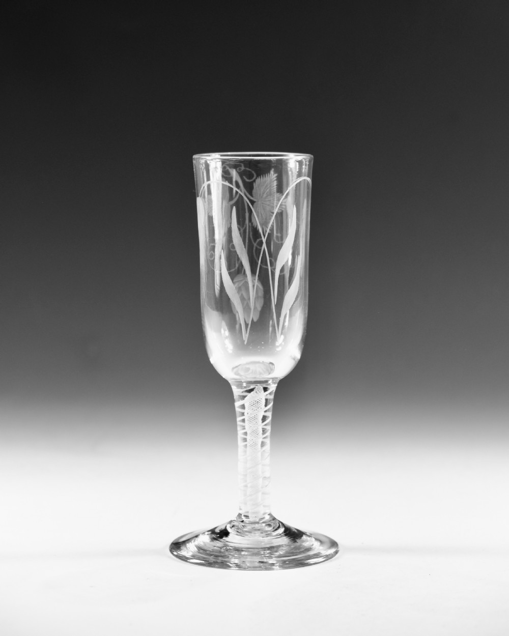 An eighteenth-century lead glass ale flute featuring an engraved hops and barley motif on an elongated bowl, resting upon a double series opaque twist stem and a conical foot. View II