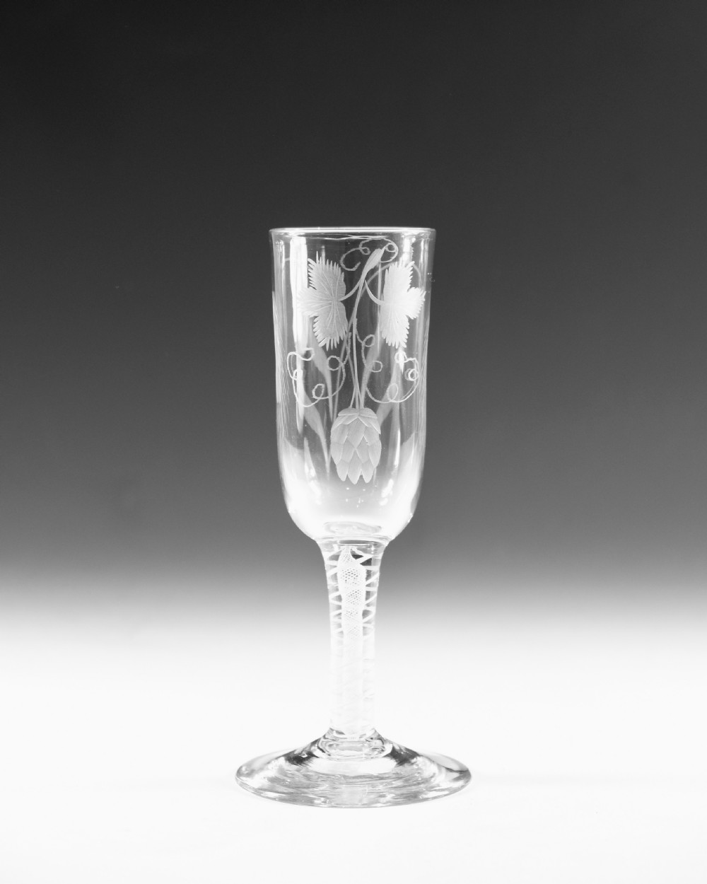 An eighteenth-century lead glass ale flute featuring an engraved hops and barley motif on an elongated bowl, resting upon a double series opaque twist stem and a conical foot. View III