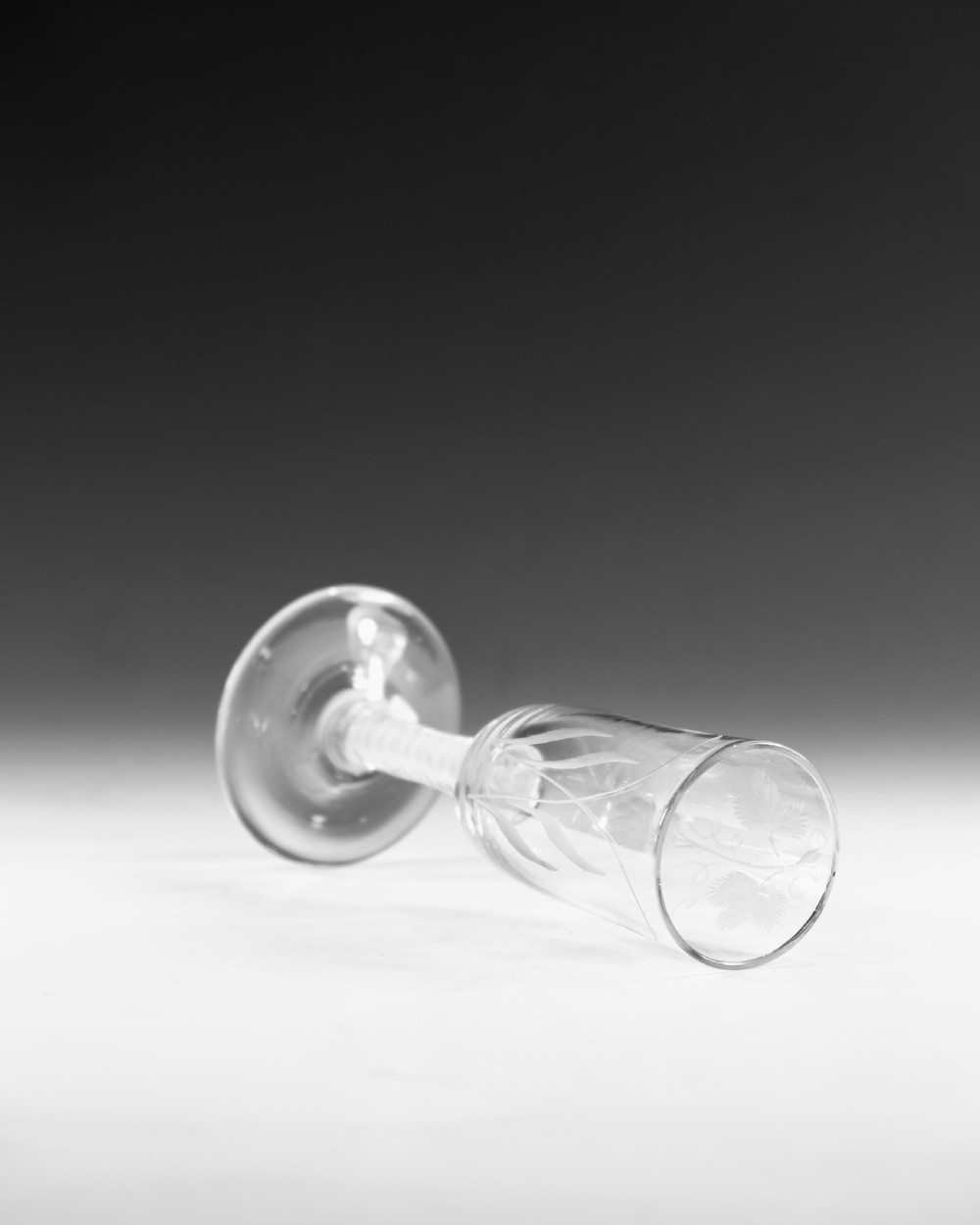 An eighteenth-century lead glass ale flute featuring an engraved hops and barley motif on an elongated bowl, resting upon a double series opaque twist stem and a conical foot. View V