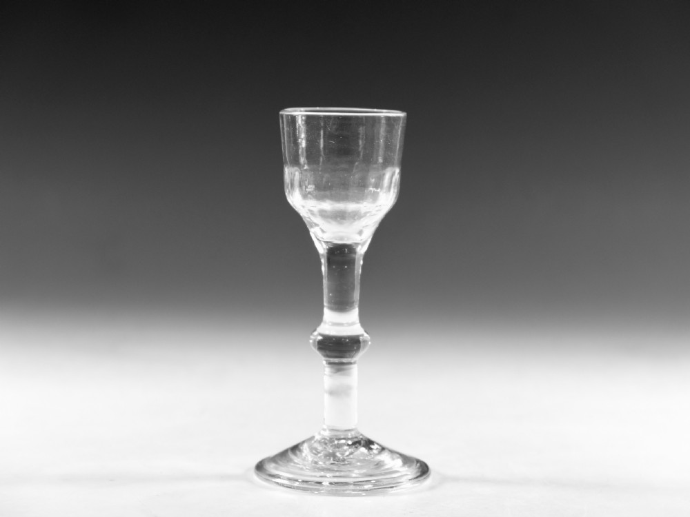 A clear Georgian balustroid wine glass featuring a stem with a central knop resting on a circular foot.