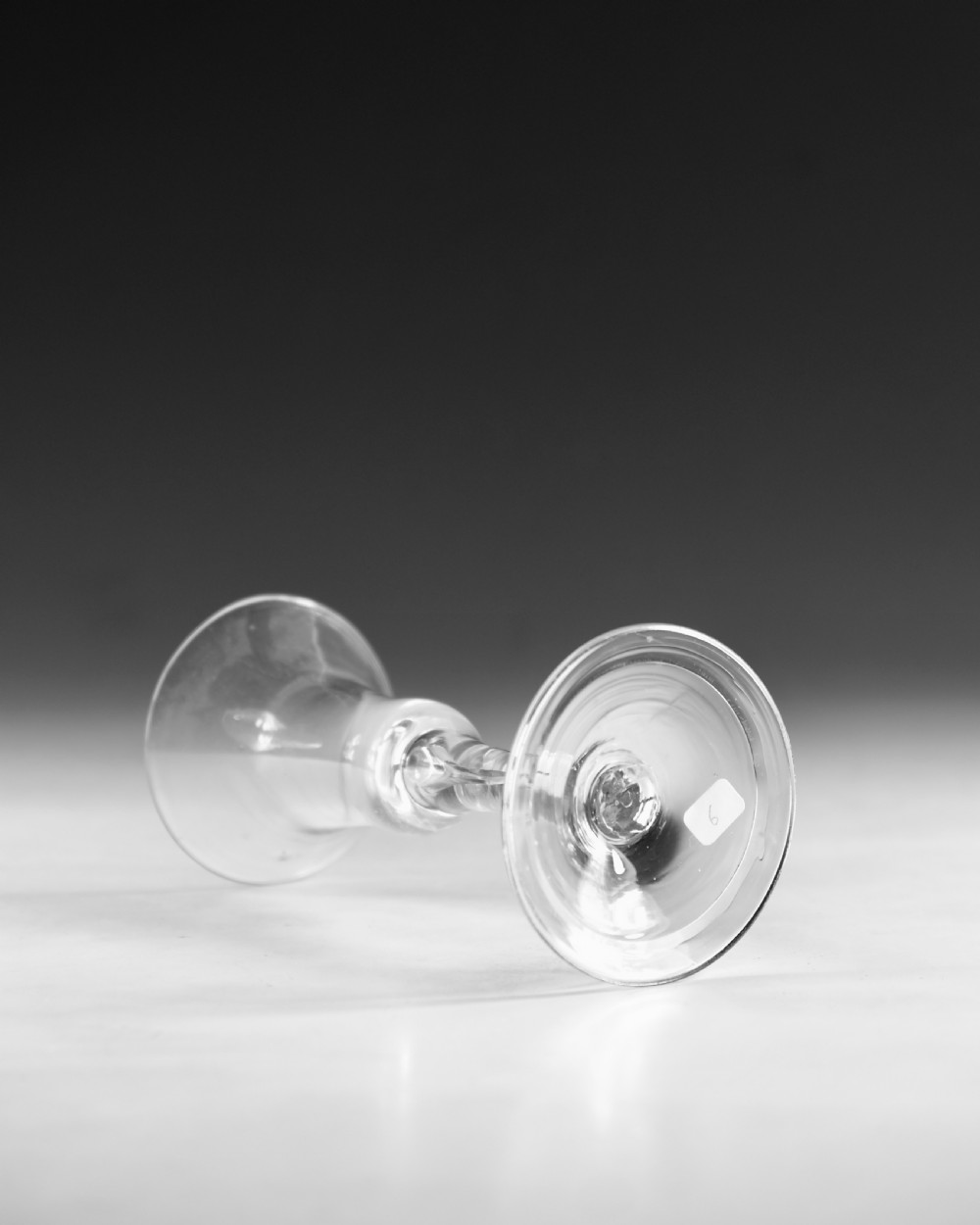 An 18th-century English clear lead glass wine glass featuring a flared bell bowl, a plain stem with a central air tear, and a circular conical foot. View III