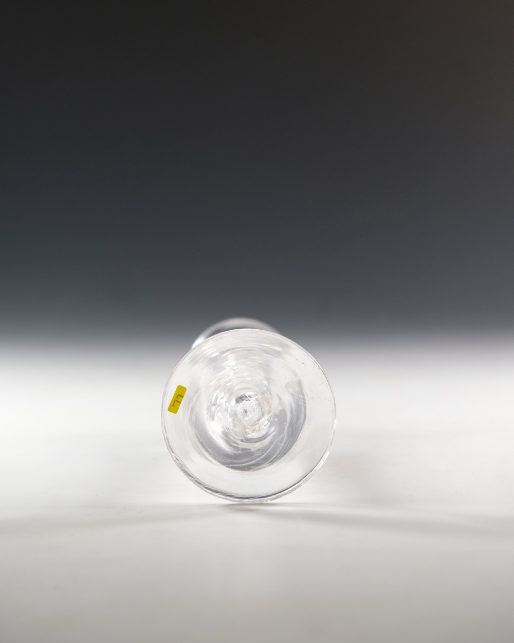 An antique clear lead glass cordial glass featuring a flared funnel bowl, a central mercury air-twist stem, and a wide conical base. View V
