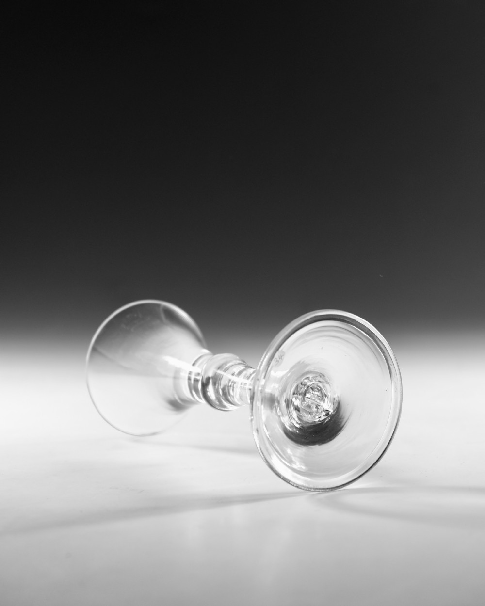 An eighteenth-century clear glass wine glass featuring a flared funnel bowl, a central stem knop, and a conical foot. View III