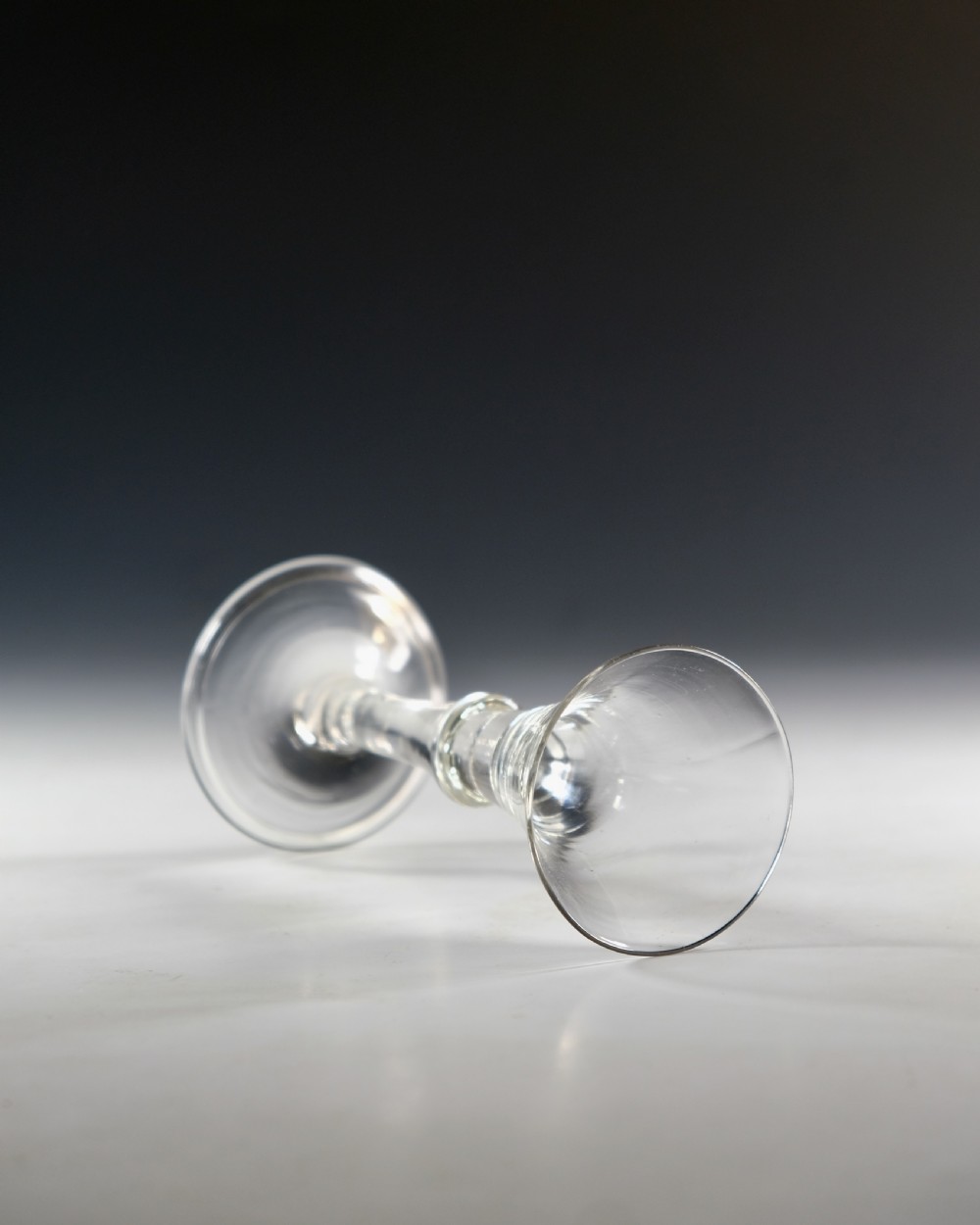 An eighteenth-century clear glass wine glass featuring a flared funnel bowl, a central stem knop, and a conical foot. View IV
