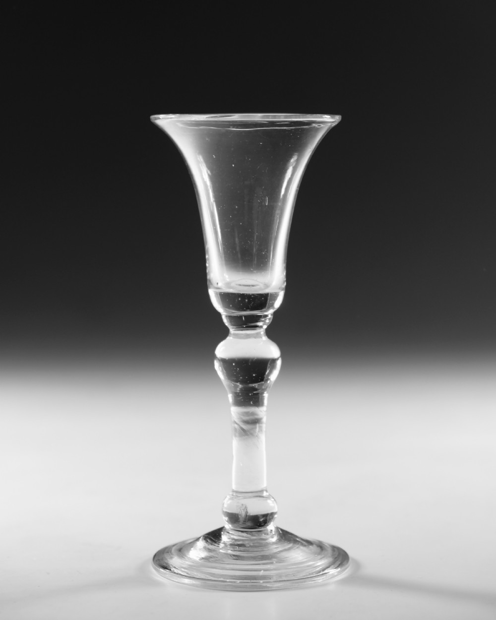 A Georgian clear glass wine glass featuring a flared bell bowl, a knopped stem, and a circular conical foot. View II