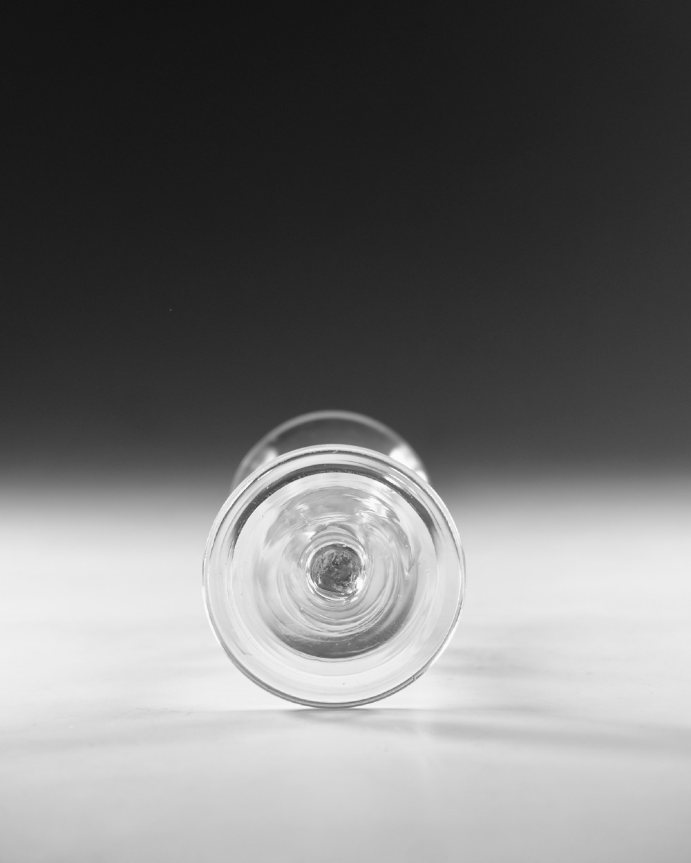 A Georgian clear glass wine glass featuring a flared bell bowl, a knopped stem, and a circular conical foot. View V