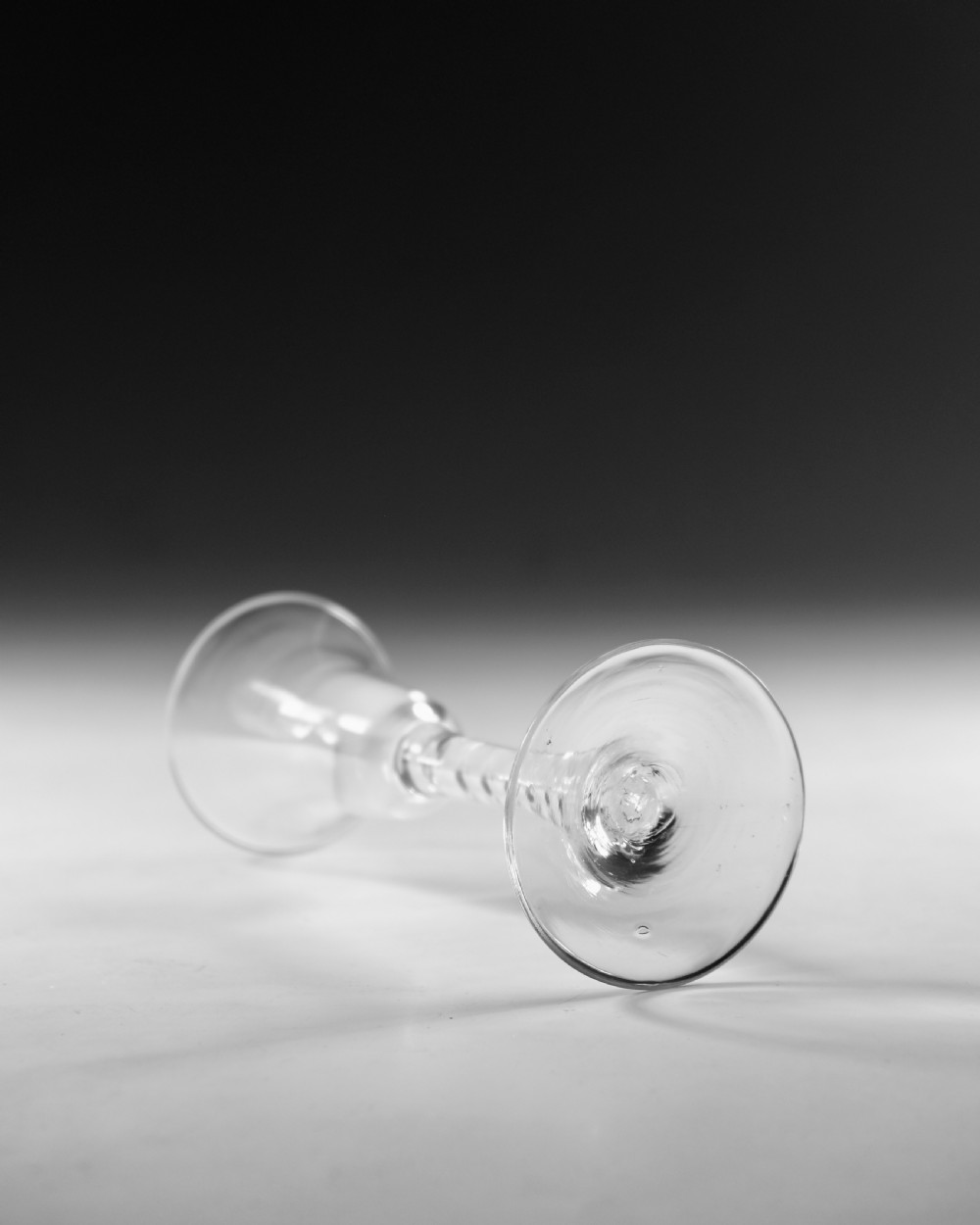 A Georgian clear glass wine goblet with a flared bell bowl and an opaque white spiral twist stem on a circular conical foot. View III