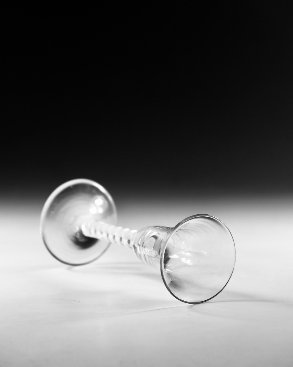 A Georgian clear glass wine goblet with a flared bell bowl and an opaque white spiral twist stem on a circular conical foot. View IV