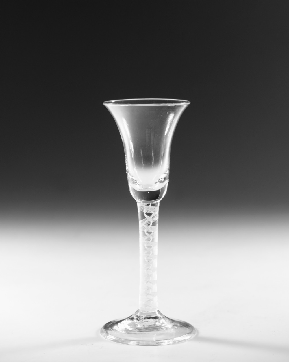 A Georgian clear glass wine goblet with a flared bell bowl and an opaque white spiral twist stem on a circular conical foot. View VI