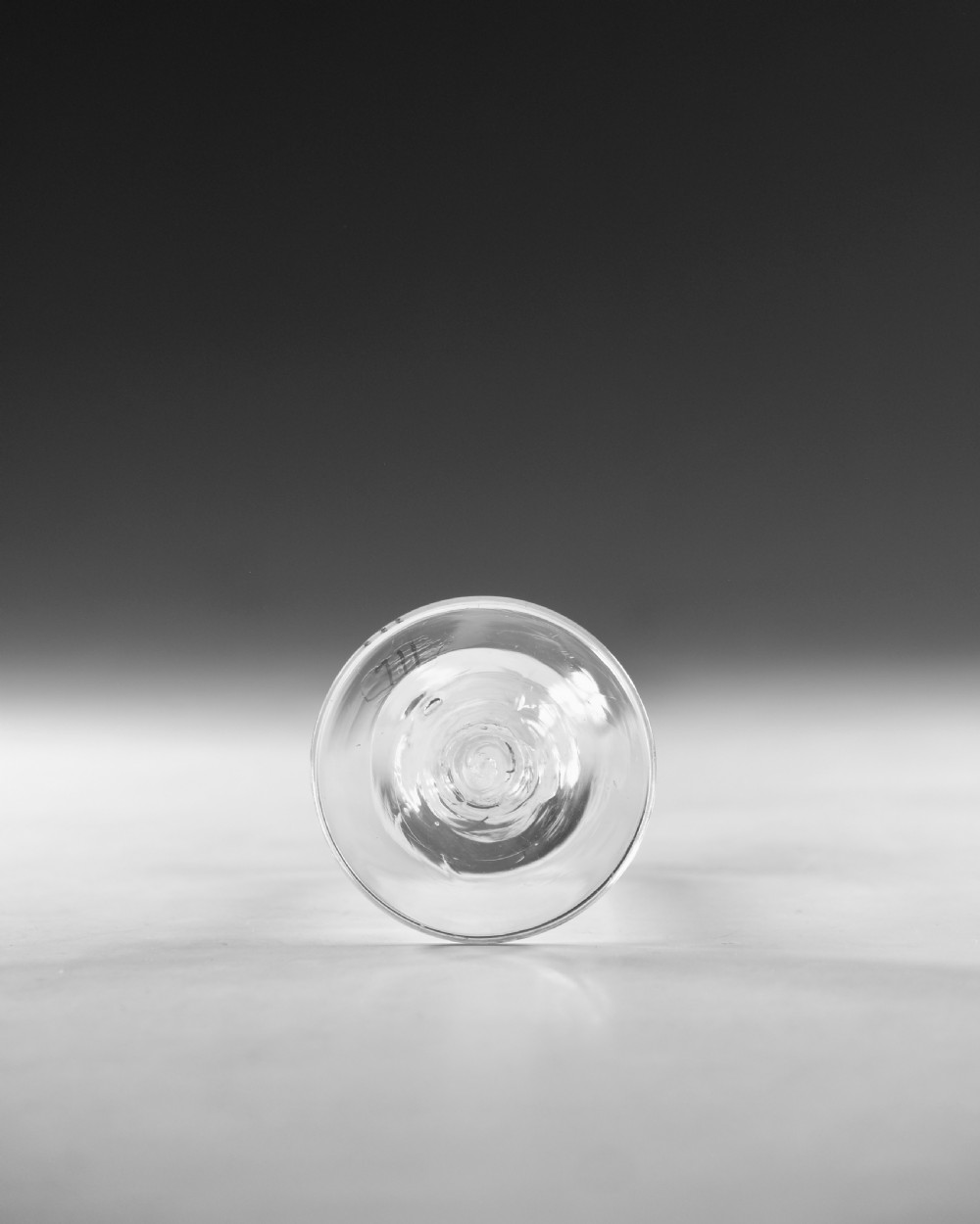 An 18th-century clear glass wine glass featuring an internal white opaque twist stem and a wide conical foot. View VI