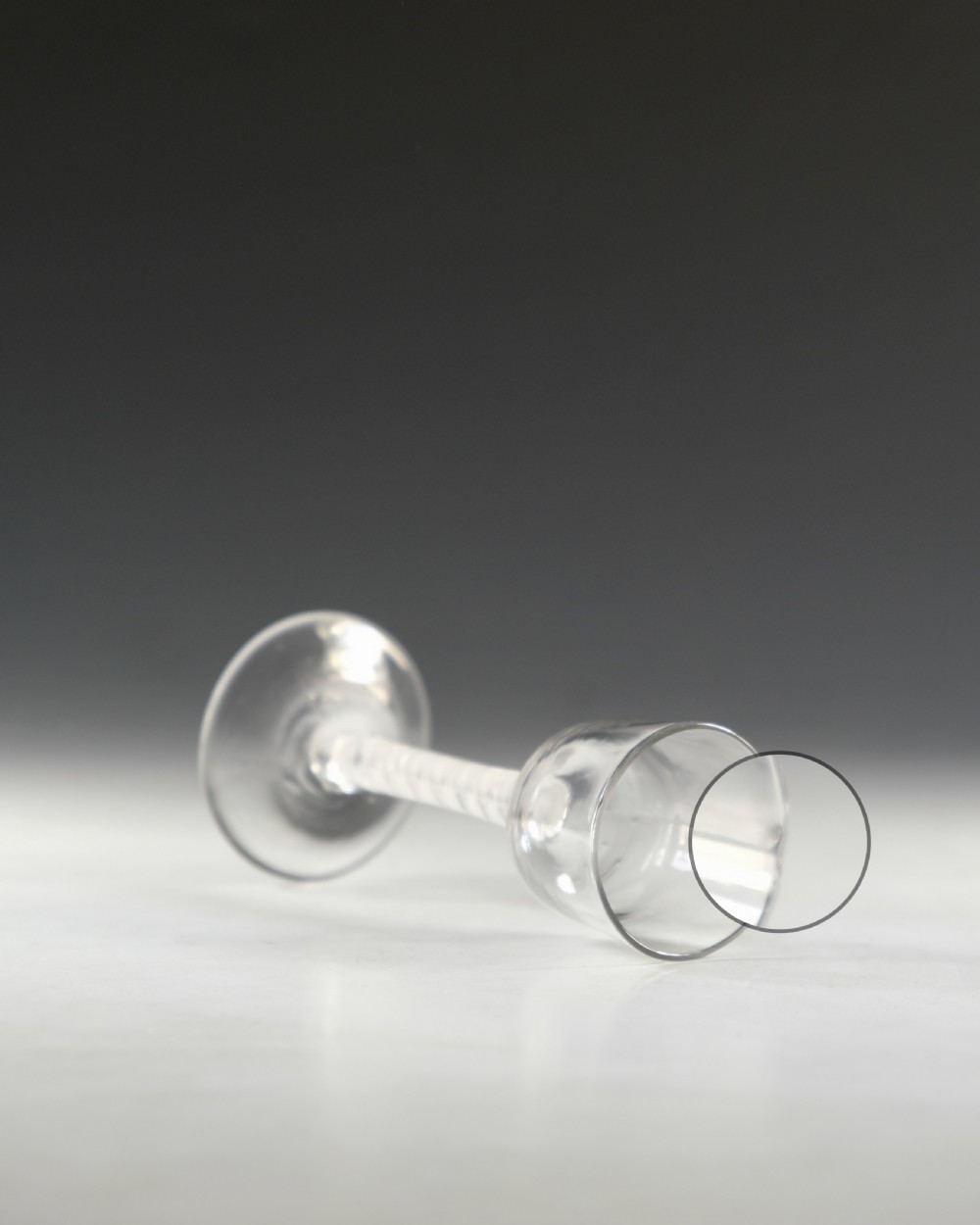 An 18th-century clear glass wine glass featuring an internal white opaque twist stem and a wide conical foot. View VIII