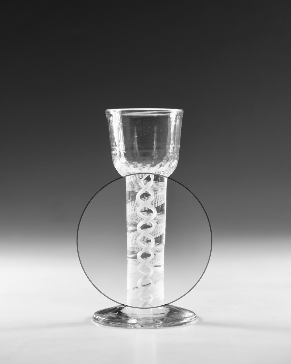 An eighteenth-century clear lead glass wine glass featuring an internal opaque white spiral twist within the stem and a conical foot. View III