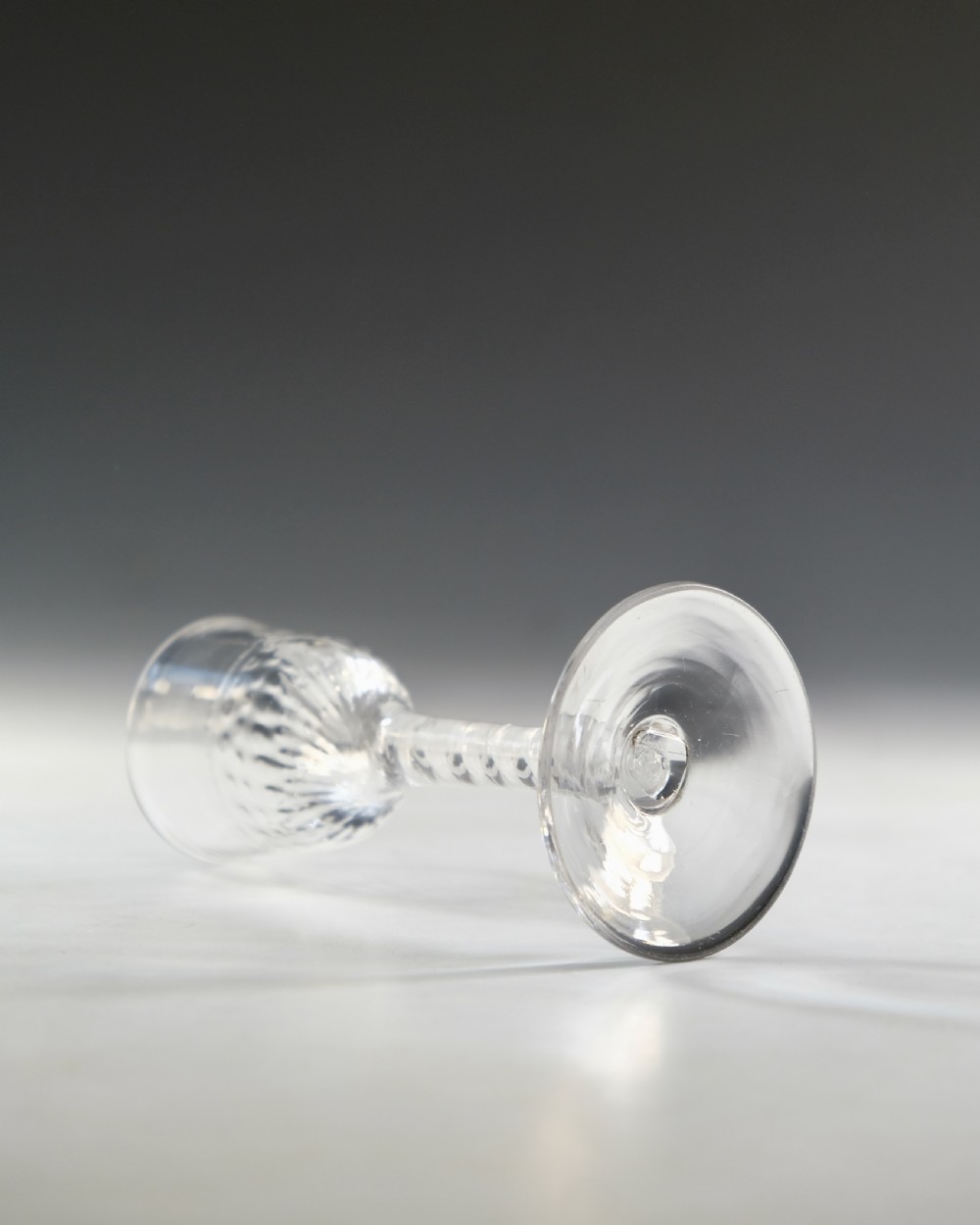 An eighteenth-century clear lead glass wine glass featuring an internal opaque white spiral twist within the stem and a conical foot. View IV