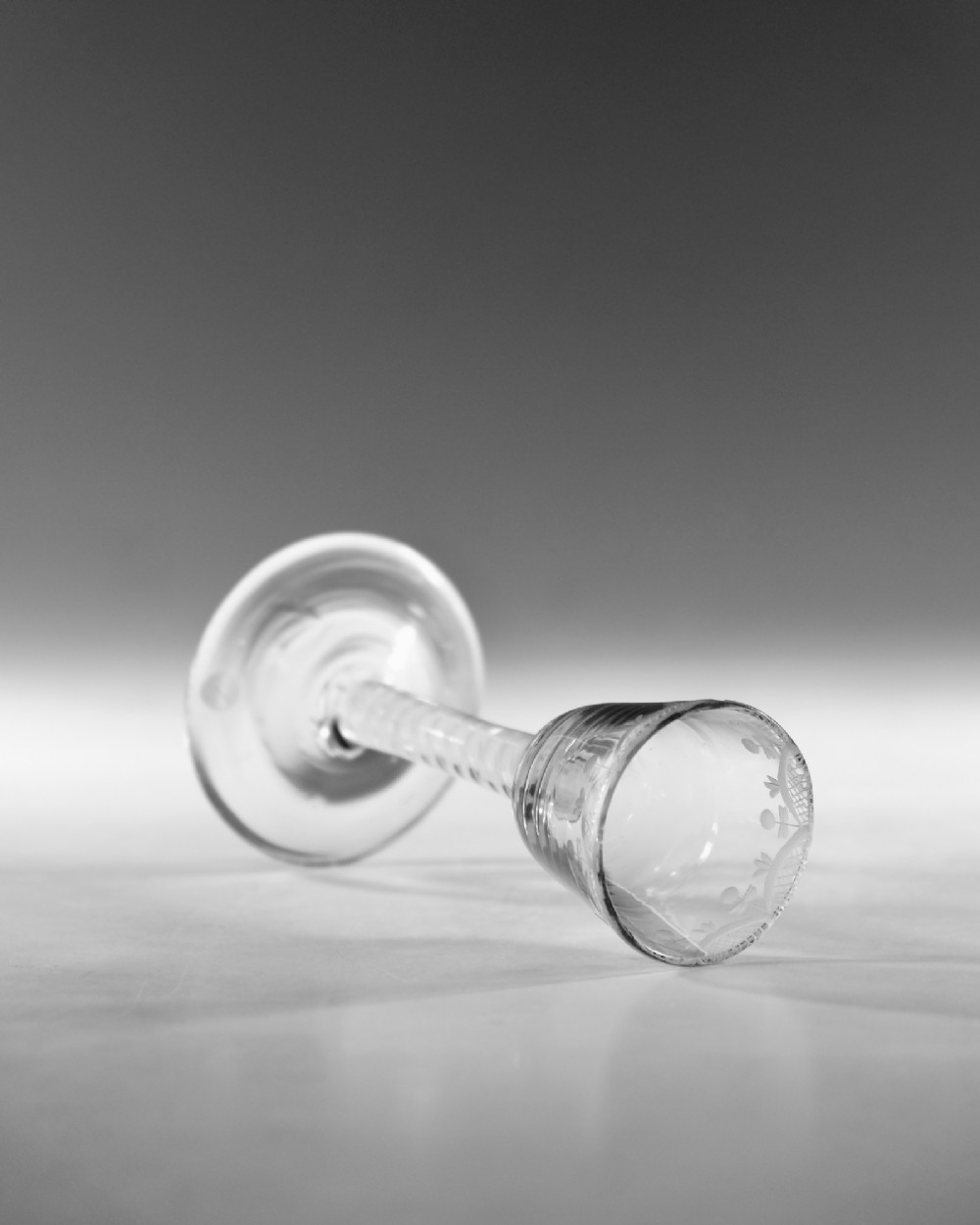 An 18th-century Georgian clear lead glass wine glass featuring an engraved bowl rim, an opaque twist stem, and a circular conical foot. View IV