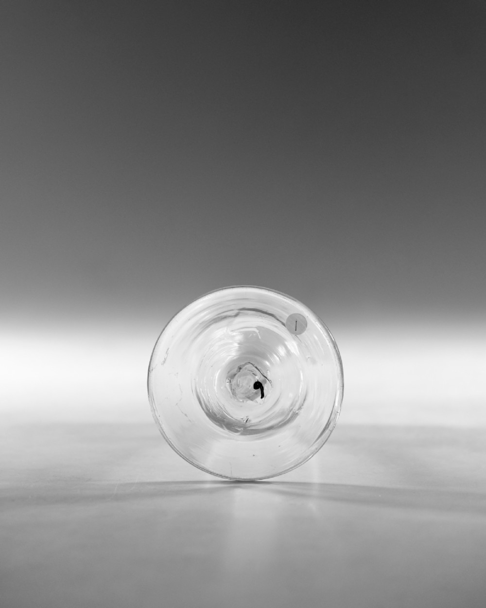 An 18th-century Georgian clear lead glass wine glass featuring an engraved bowl rim, an opaque twist stem, and a circular conical foot. View V