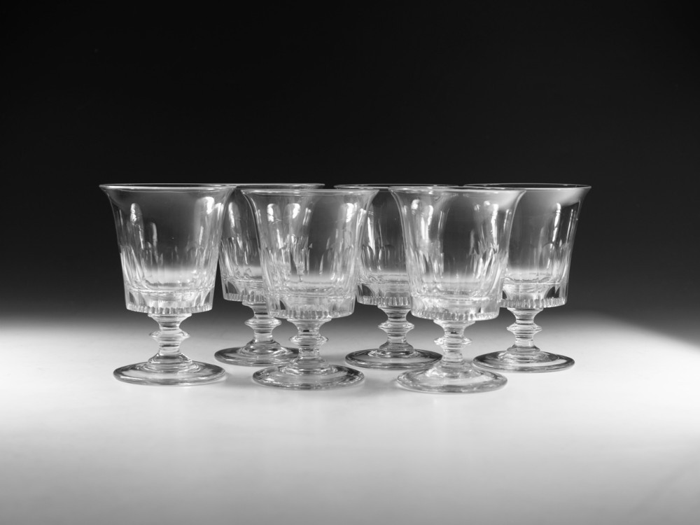 A set of six English Georgian clear glass rummers with cut fluted bowls and knopped stems on circular bases.