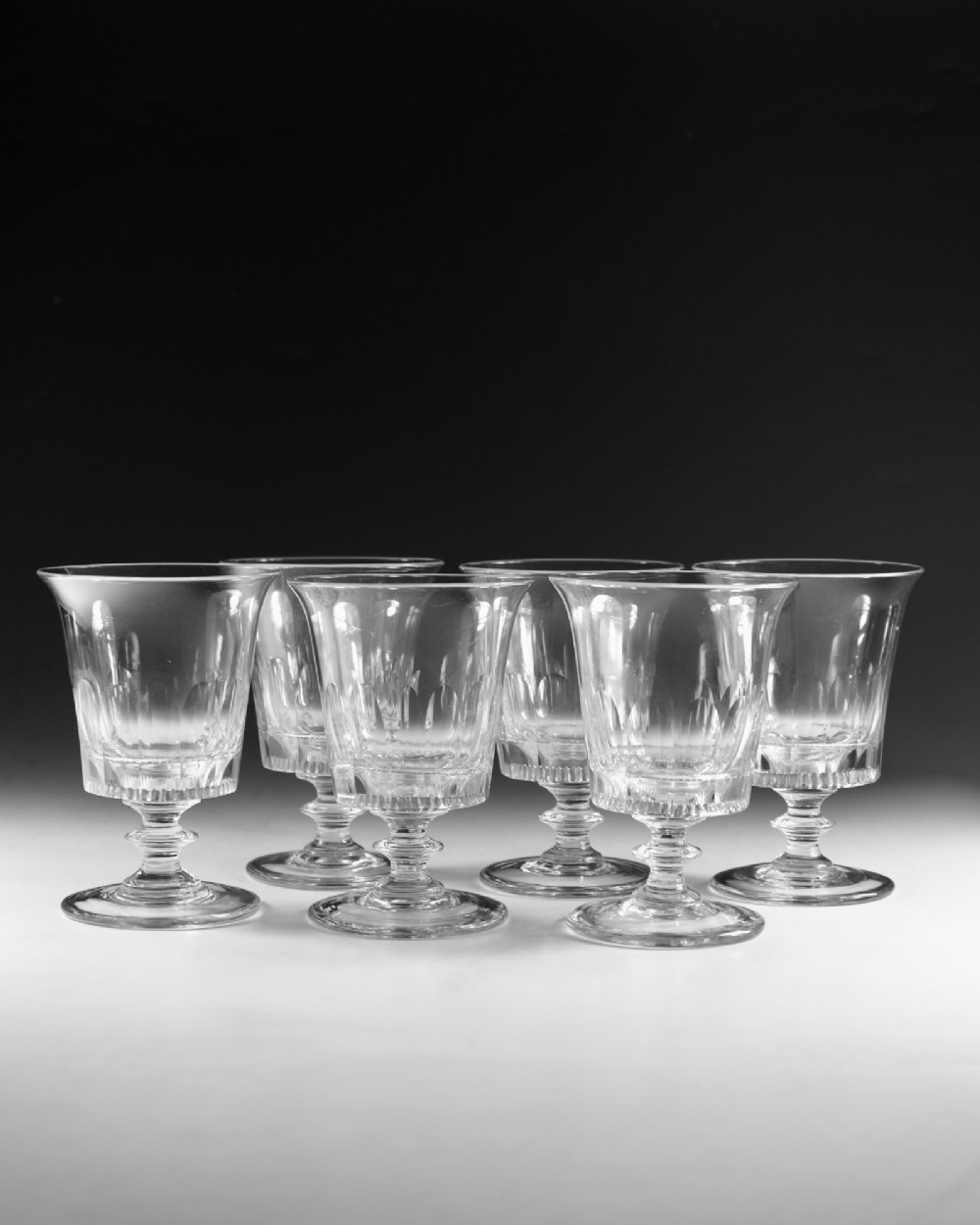 A set of six English Georgian clear glass rummers with cut fluted bowls and knopped stems on circular bases. View IV