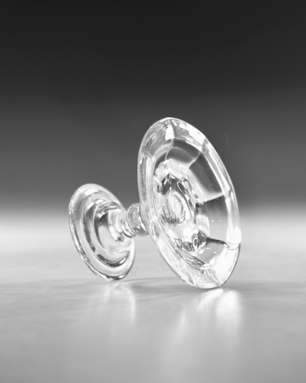 An eighteenth-century Georgian clear lead glass patch stand featuring a shallow rimmed top, a multi-knopped baluster stem, and a circular folded foot. View V