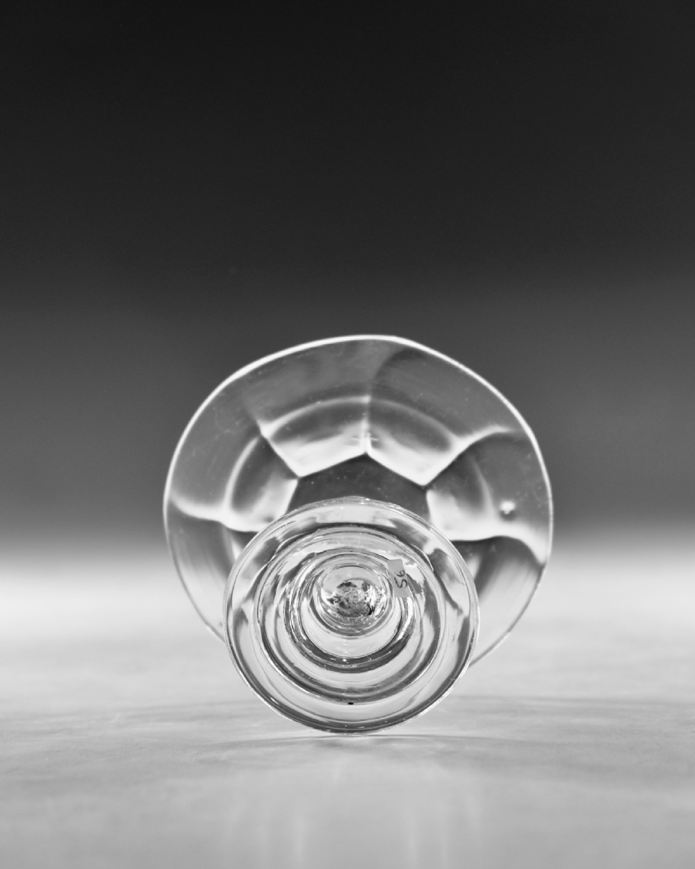 An eighteenth-century Georgian clear lead glass patch stand featuring a shallow rimmed top, a multi-knopped baluster stem, and a circular folded foot. View VII
