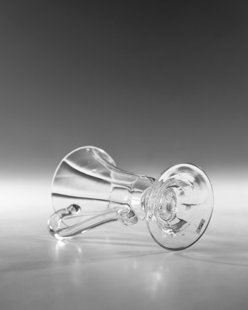 An 18th-century clear glass jelly vessel featuring a fluted bell-shaped bowl, a single side handle, a knopped stem element, and a circular foot. View IV
