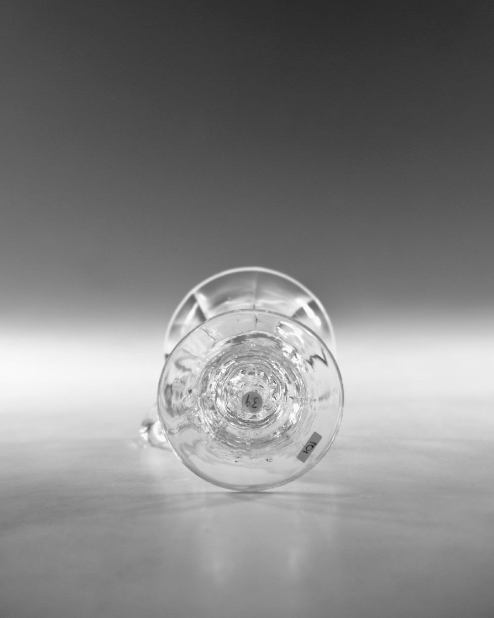 An 18th-century clear glass jelly vessel featuring a fluted bell-shaped bowl, a single side handle, a knopped stem element, and a circular foot. View VI