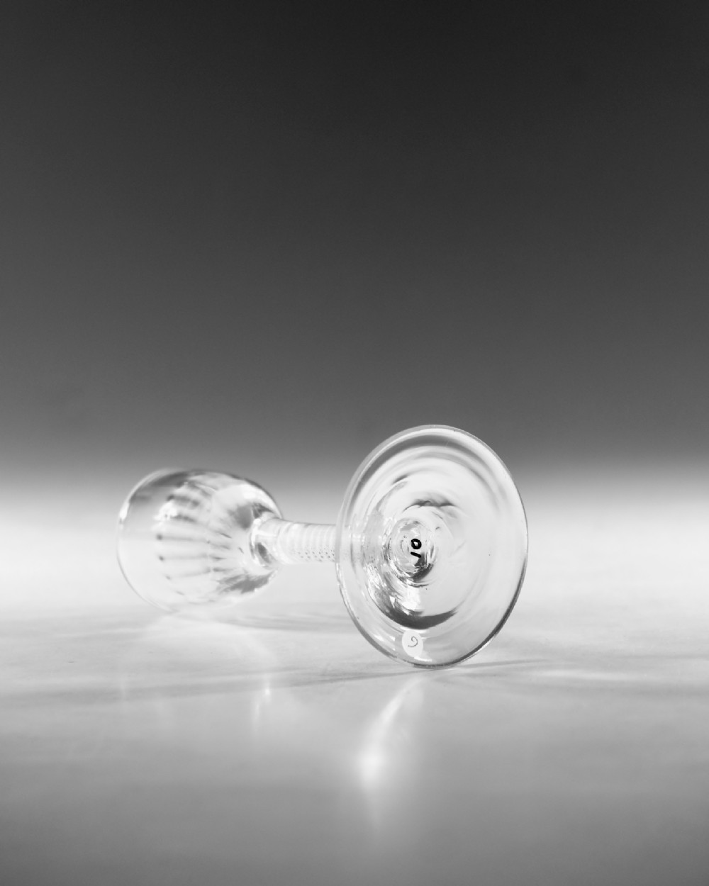 An eighteenth-century clear glass wine goblet featuring a rounded funnel bowl, a internal spiral twist stem, and a wide conical foot. View III