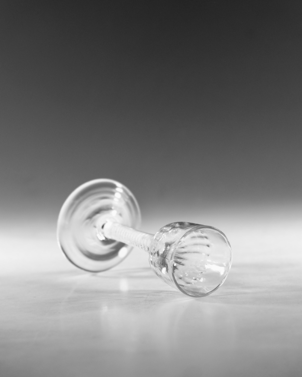 An eighteenth-century clear glass wine goblet featuring a rounded funnel bowl, a internal spiral twist stem, and a wide conical foot. View IV