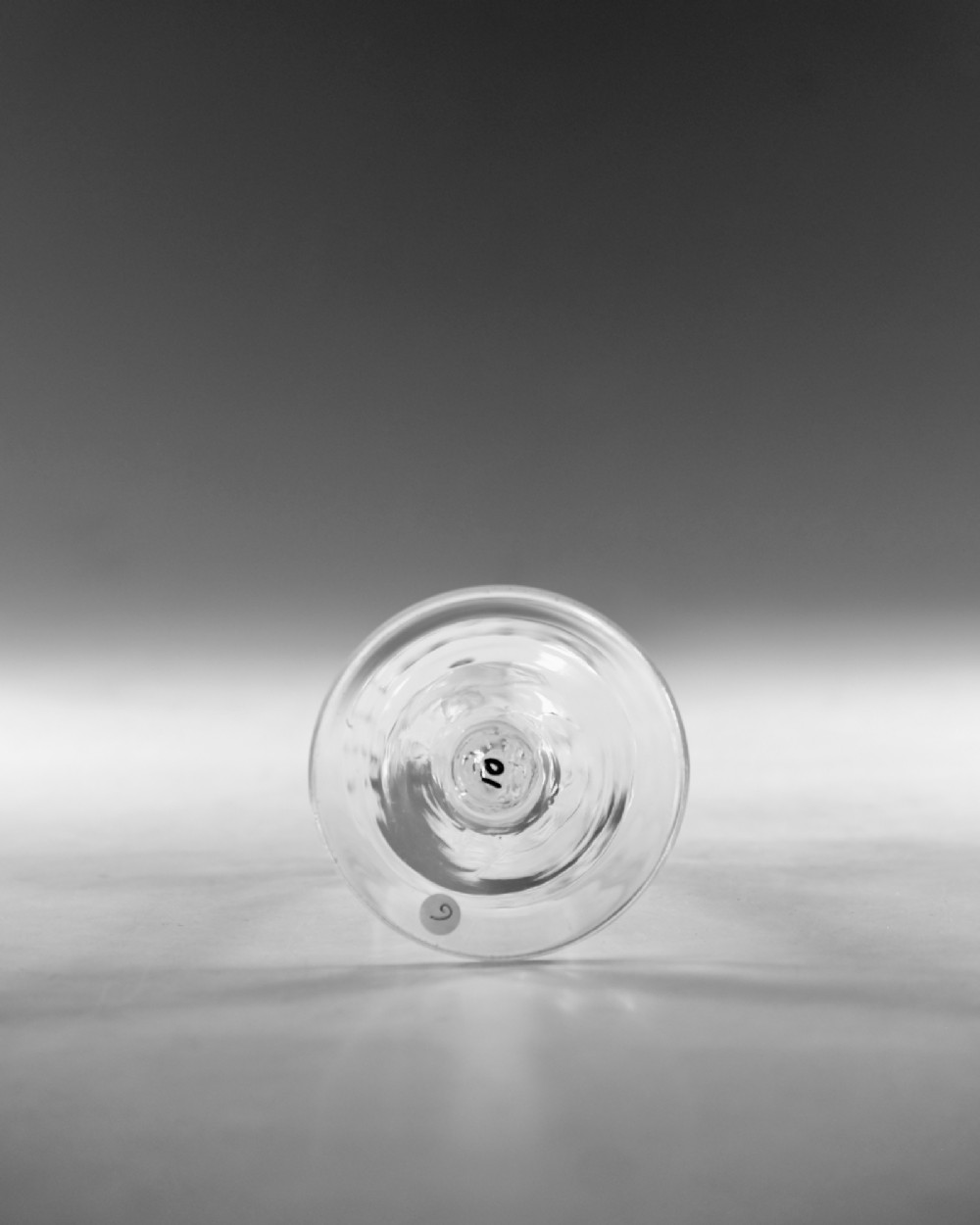 An eighteenth-century clear glass wine goblet featuring a rounded funnel bowl, a internal spiral twist stem, and a wide conical foot. View V