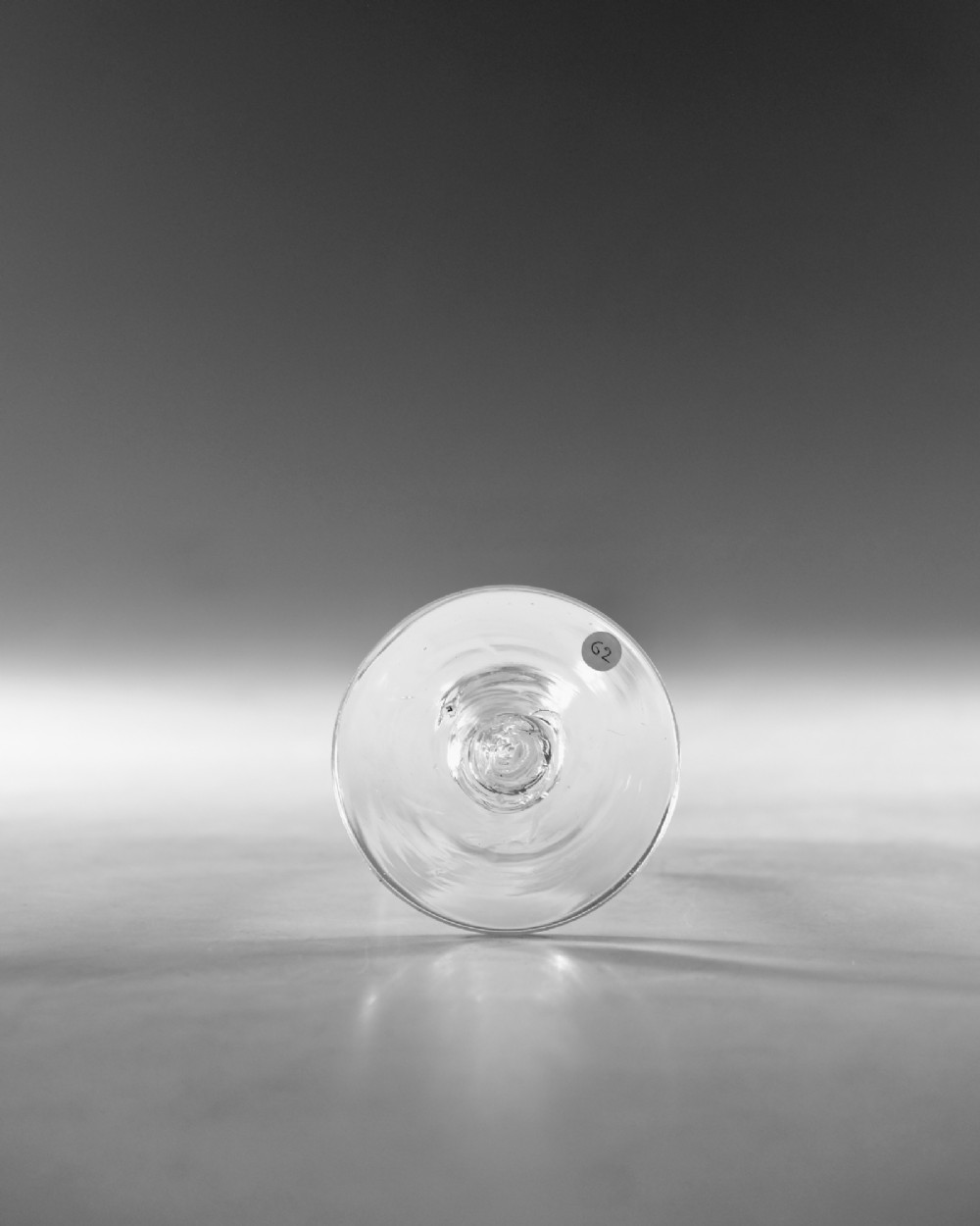 A clear glass wine goblet featuring a wheel-engraved rim pattern, an air twist stem, and a flat conical foot, dating to circa 1755. View VI