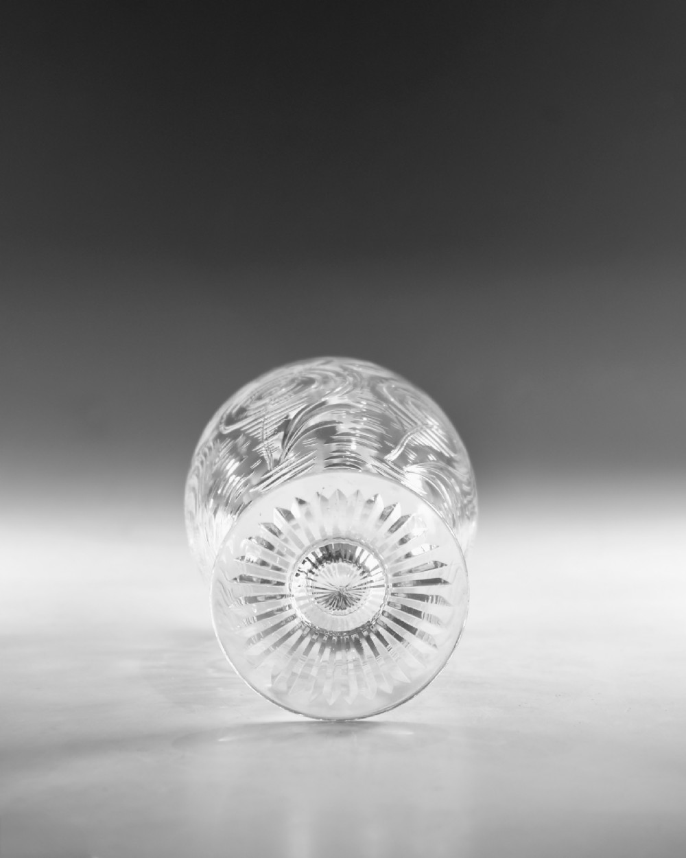 A pair of antique clear glass decanters with intaglio water lily engravings, tall slender necks, and matching glass stoppers. View VII