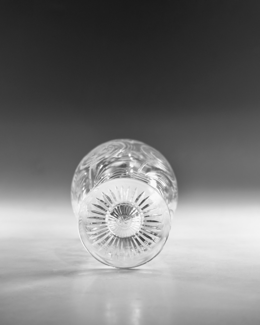 A pair of antique clear glass decanters with intaglio water lily engravings, tall slender necks, and matching glass stoppers. View XII