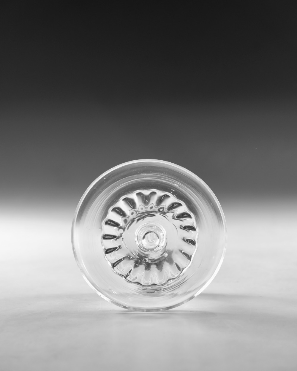 A clear Georgian lead glass patch stand featuring a shallow circular top dish elevated on a baluster stem and a spreading foot. View III