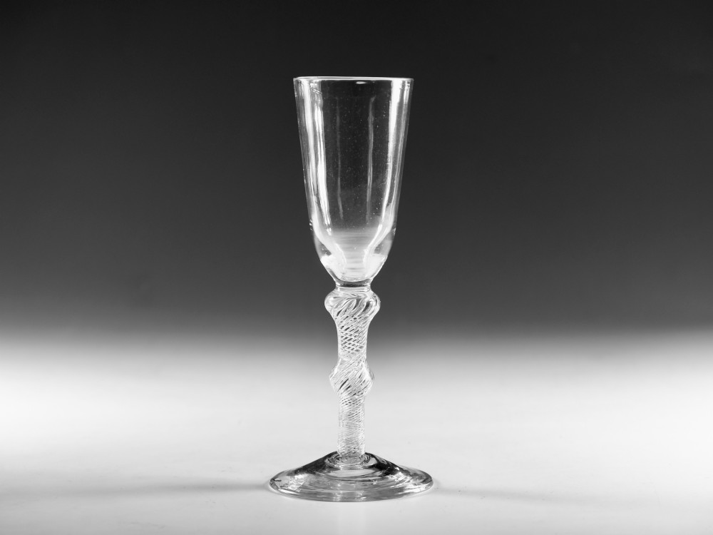 A Georgian clear glass ale flute with a tall bowl, knopped air twist stem, and a flat conical base.
