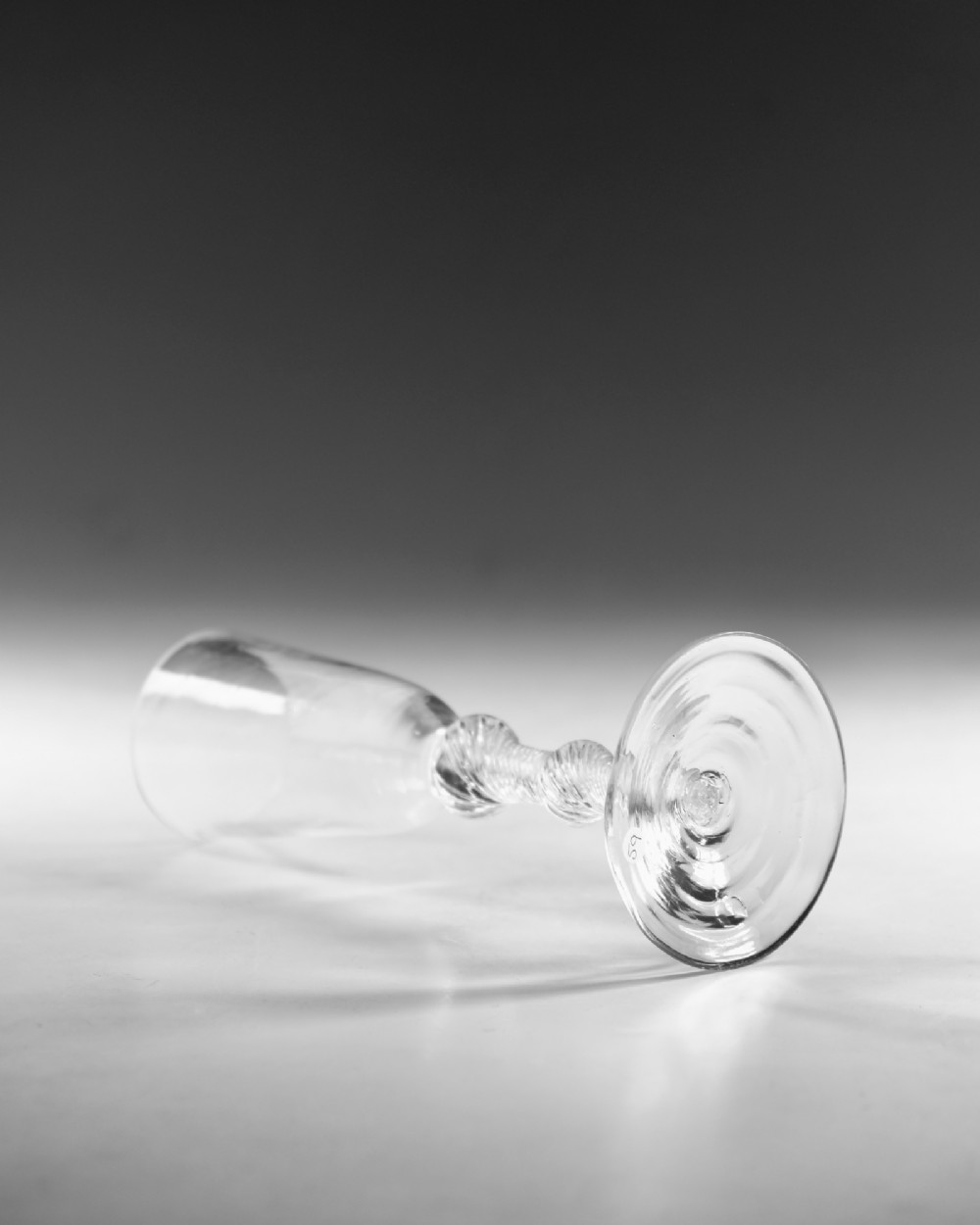 A Georgian clear glass ale flute with a tall bowl, knopped air twist stem, and a flat conical base. View III