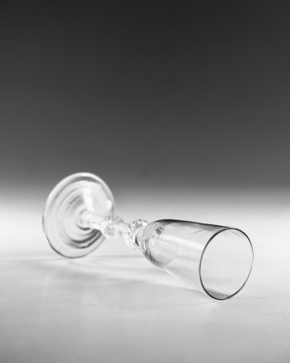 A Georgian clear glass ale flute with a tall bowl, knopped air twist stem, and a flat conical base. View IV
