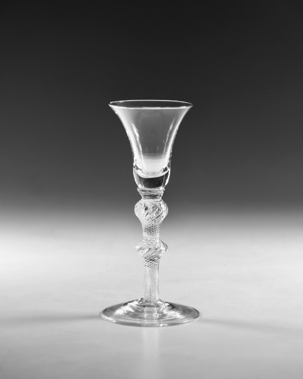 A clear hand-blown Georgian lead crystal wine glass featuring a bell-shaped bowl, a knopped air twist stem, and a broad conical foot. View II