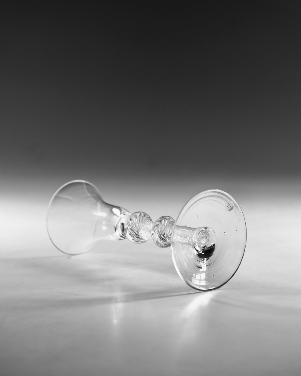 A clear hand-blown Georgian lead crystal wine glass featuring a bell-shaped bowl, a knopped air twist stem, and a broad conical foot. View III
