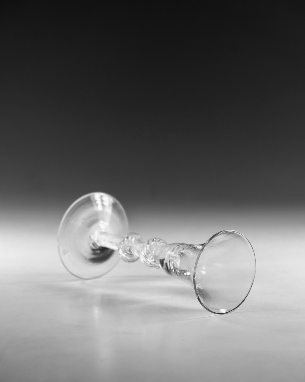 A clear hand-blown Georgian lead crystal wine glass featuring a bell-shaped bowl, a knopped air twist stem, and a broad conical foot. View IV