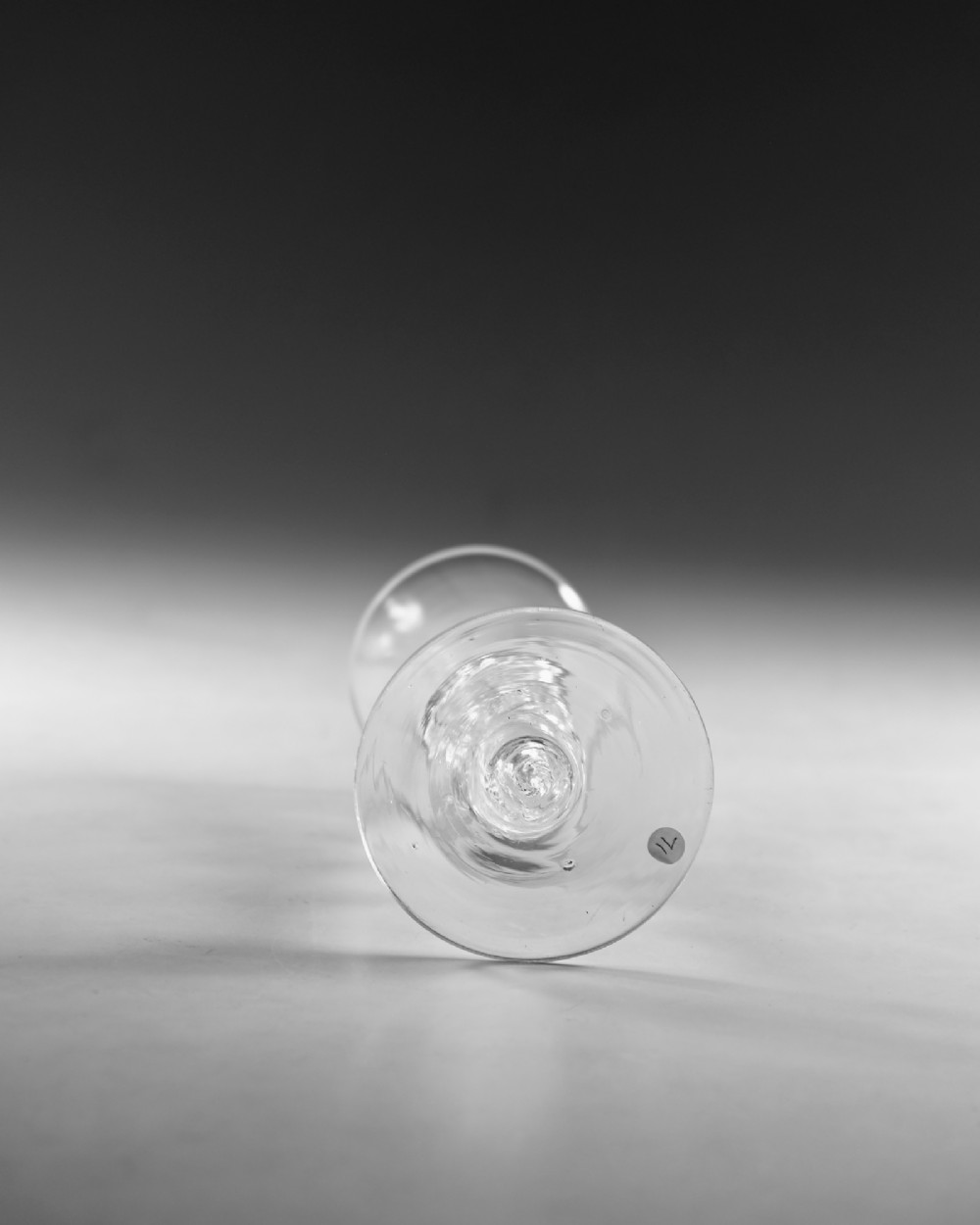 A clear hand-blown Georgian lead crystal wine glass featuring a bell-shaped bowl, a knopped air twist stem, and a broad conical foot. View V