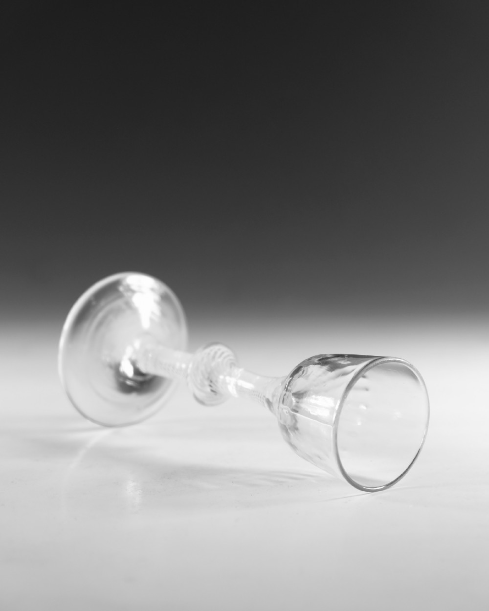 An 18th-century English Georgian clear glass wine glass featuring a funnel bowl and an opaque white twist stem with a central knop. View IV