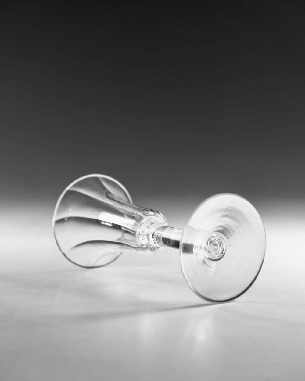 An eighteenth-century clear lead glass ale flute featuring a ribbed trumpet-shaped bowl on a straight stem with a conical base. View III