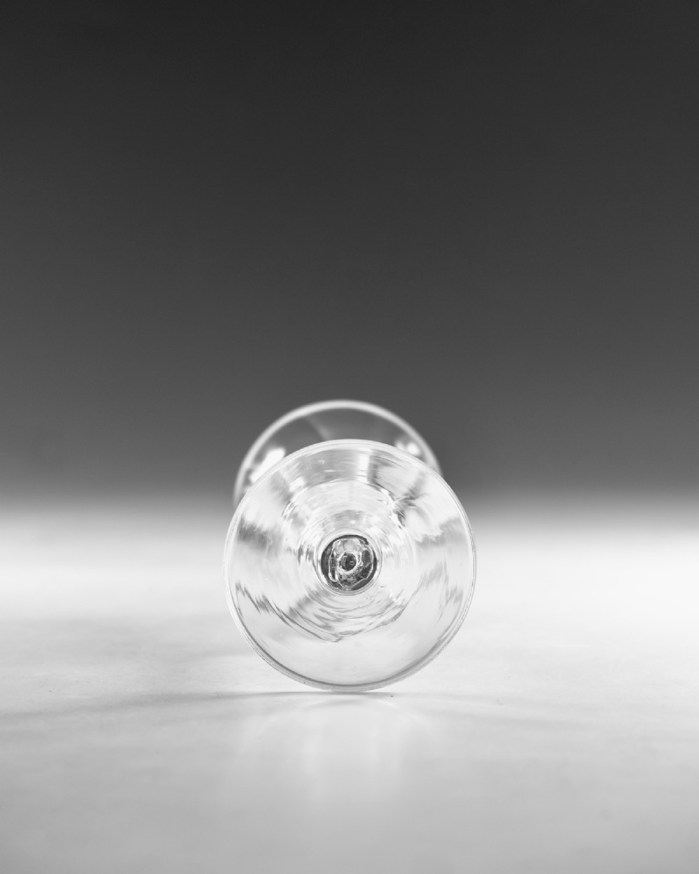 An eighteenth-century clear lead glass ale flute featuring a ribbed trumpet-shaped bowl on a straight stem with a conical base. View V
