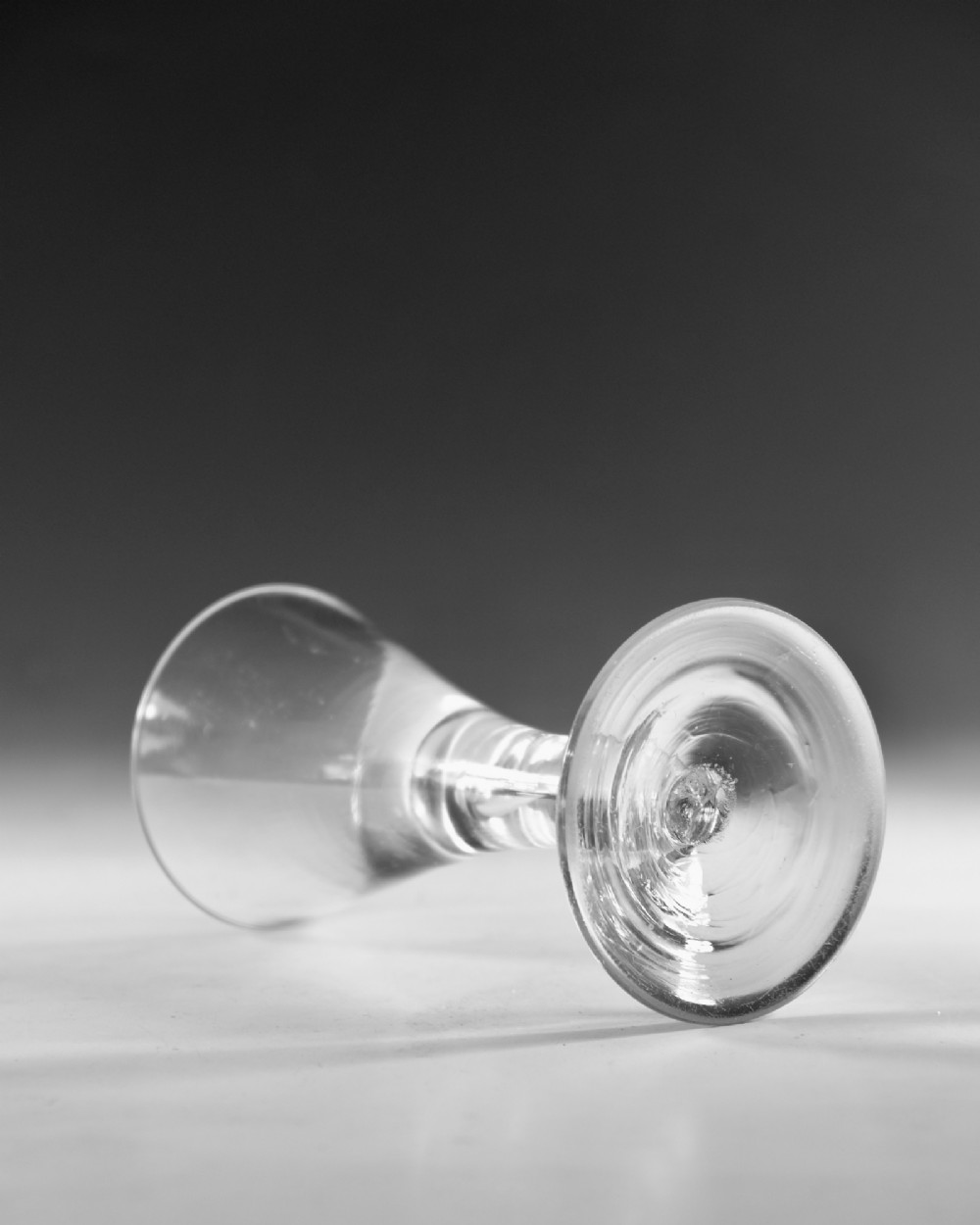 An eighteenth-century clear glass wine vessel featuring a conical bowl, a plain stem enclosing an elongated air tear, and a circular conical foot. View III